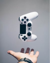 A video game controller about to be caught by a hand